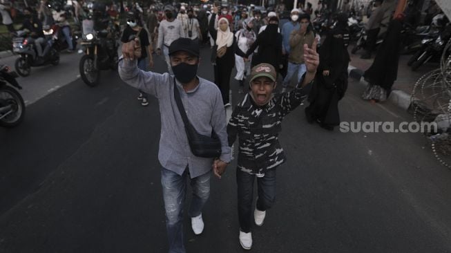 Massa pendukung Habib Rizieq Shihab berjalan saat dibubarkan oleh petugas kepolisian usai sidang putusan Habib Rizieq Shihab di depan Pengadilan Negeri Jakarta Timur, Kamis (27/5/2021). [Suara.com/Angga Budhiyanto]