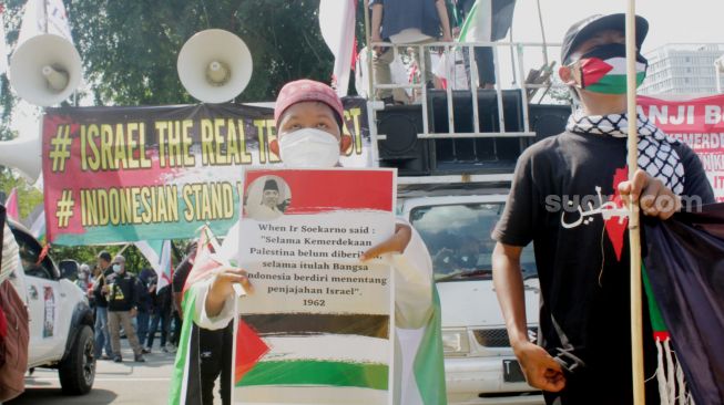 Massa mengikuti aksi solidaritas untuk Palestina di Jalan Medan Merdeka, Jakarta Pusat, Jumat (28/5/2021).  [Suara.com/Dian Latifah].