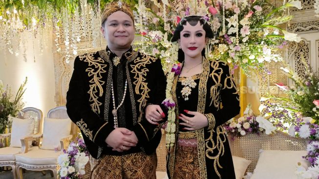 Pedangdut Nabilla Gomes dan suami, Muhammad Reza saat melangsungkan resepsi pernikahan di Aula Masjid Kubah Emas, Depok, Jawa Barat, Jumat (28/5/2021). [Suara.com/Alfian Winanto]