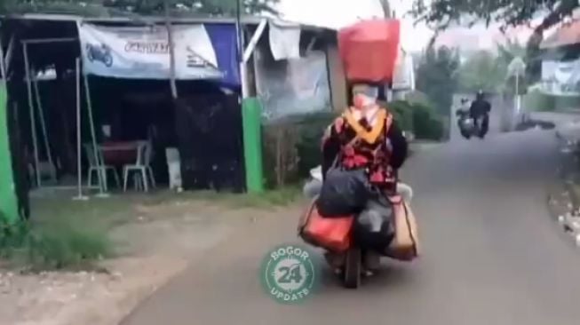 Viral, Emak-Emak Naik Motor Bawa Barang di Kepala, Netizen: Gagah!