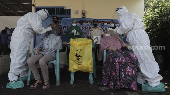 Petugas medis melakukan tes usap kepada warga di lingkungan RT 004 RW 002 Kelurahan Srengseng Sawah, Jagakarsa, Jakarta Selatan, Jumat (28/5/2021). [Suara.com/Angga Budhiyanto]