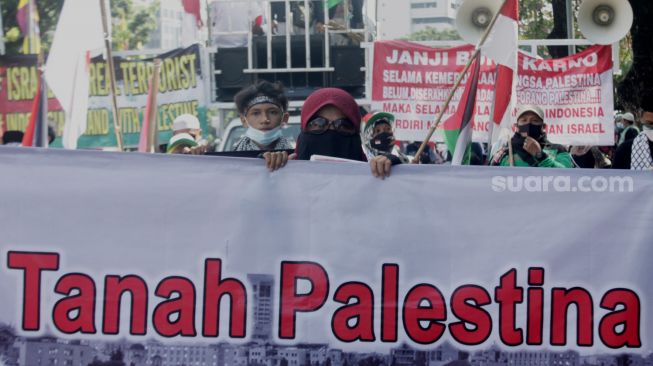 Massa mengikuti aksi solidaritas untuk Palestina di Jalan Medan Merdeka, Jakarta Pusat, Jumat (28/5/2021).  [Suara.com/Dian Latifah].