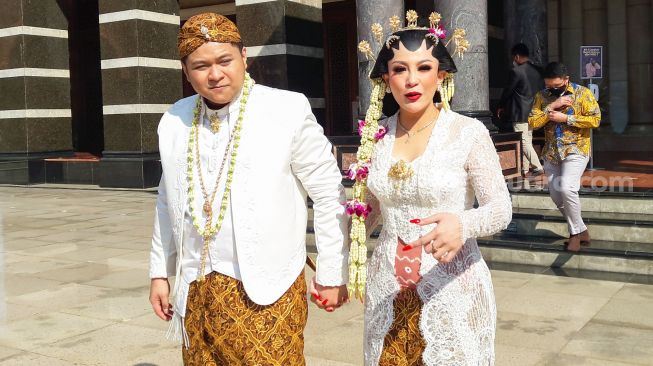 Pedangdut Nabila Gomes dan suaminya, Muhammad Reza usai melangsungkan akad nikah di Masjid Kubah Emas, Depok, Jawa Barat, Jumat (28/5/2021). [Suara.com/Alfian Winanto]