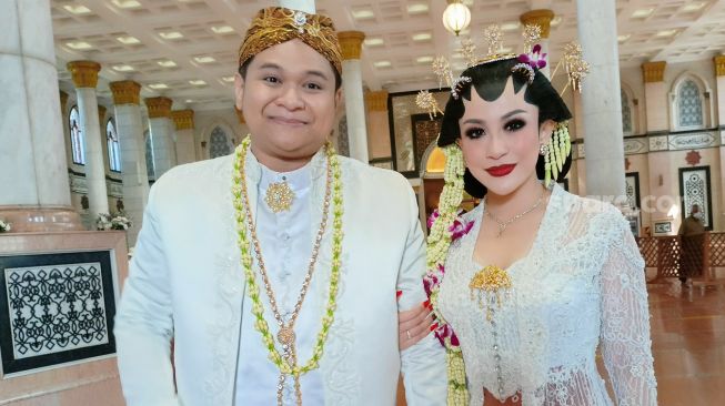 Pedangdut Nabila Gomes dan suaminya, Muhammad Reza usai melangsungkan akad nikah di Masjid Kubah Emas, Depok, Jawa Barat, Jumat (28/5/2021). [Suara.com/Alfian Winanto]