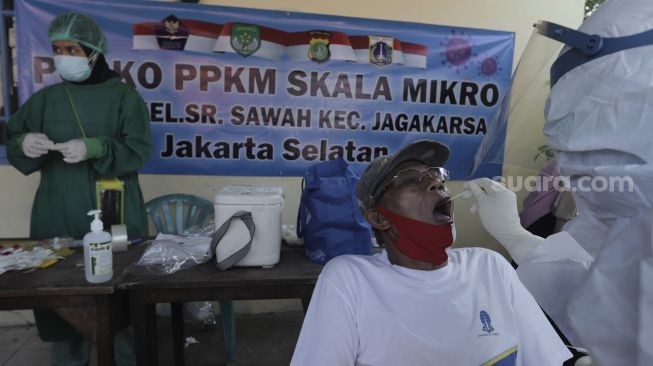 Petugas medis melakukan tes usap kepada warga di lingkungan RT 004 RW 002 Kelurahan Srengseng Sawah, Jagakarsa, Jakarta Selatan, Jumat (28/5/2021). [Suara.com/Angga Budhiyanto]