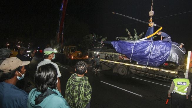 Sejumlah warga melihat proses evakuasi pengangkatan helikopter latih yang jatuh di Setu Rawa Jemblong, Buperta, Depok, Jawa Barat, Sabtu (29/5/2021) dini hari. [ANTARA FOTO/Asprilla Dwi Adha]