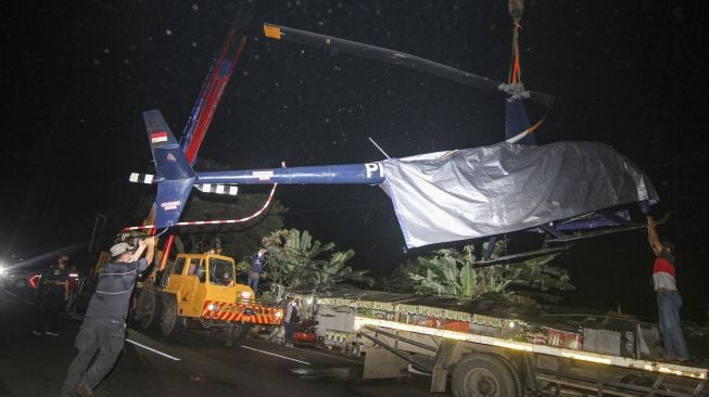 Petugas KNKT melakukan proses evakuasi pengangkatan helikopter latih yang jatuh di Setu Rawa Jemblong, Buperta, Depok, Jawa Barat, Sabtu (29/5/2021) dini hari. [ANTARA FOTO/Asprilla Dwi Adha]