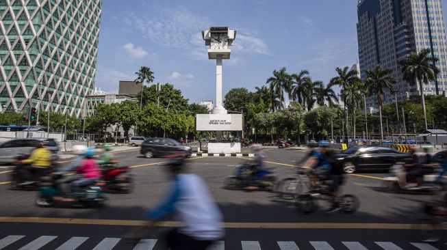 Pengendara melintas di dekat Menara Jam Thamrin di Jalan MH Thamrin, Jakarta, Minggu (30/5/2021). ANTARA FOTO/Dhemas Reviyanto
