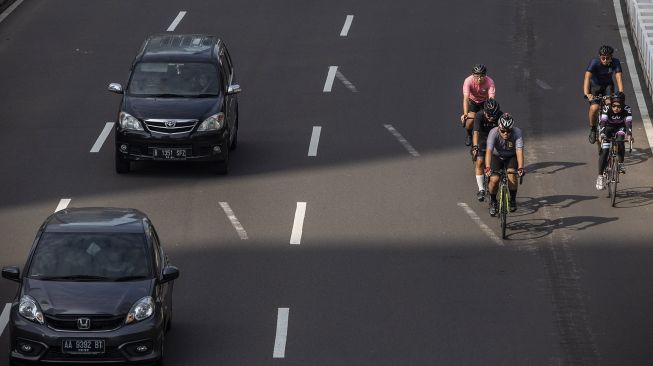 Pesepeda memacu kecepatan saat melintas di Jalan Jenderal Sudirman, Jakarta, Minggu (30/5/2021).  ANTARA FOTO/Dhemas Reviyanto