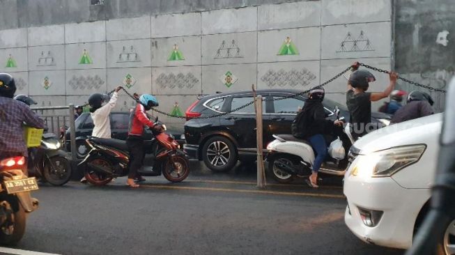 Beberapa pengendara sepeda motor nekat memutar balik untuk menghindari genangan air di Underpass Kentungan, Sabtu (29/5/2021). - (SuaraJogja.id/Hiskia Andika)