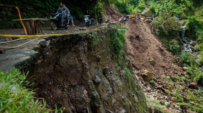 Sejumlah pengendara melintas di jalan yang longsor di Kecamatan Lebakgedong, Lebak, Banten, Minggu (30/5/2021). ANTARA FOTO/Muhammad Bagus Khoirunas