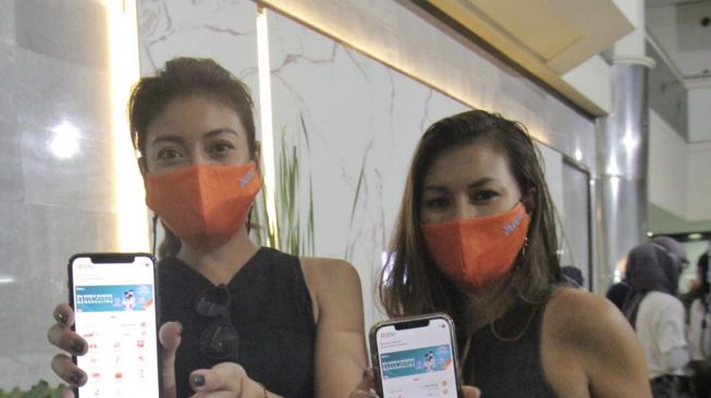 Marianne Rumantir (kanan) dan Sigi Wimala (kiri) menunjukkan aplikasi BNI Mobile Banking. (Dok: Bank Mandiri)