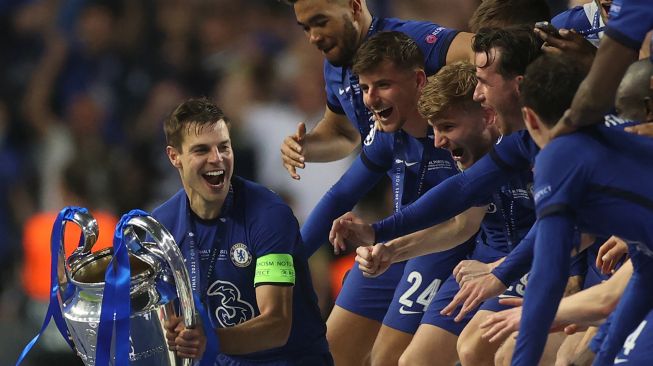 Bek Chelsea Cesar Azpilicueta (tengah) mengangkat trofi Liga Champions setelah memenangkan pertandingan final Liga Champions melawan Manchester City di Stadion Dragao, Porto, Portugal, Minggu (30/5/2021) dini hari WIB.  PIERRE-PHILIPPE MARCOU / POOL / AFP
