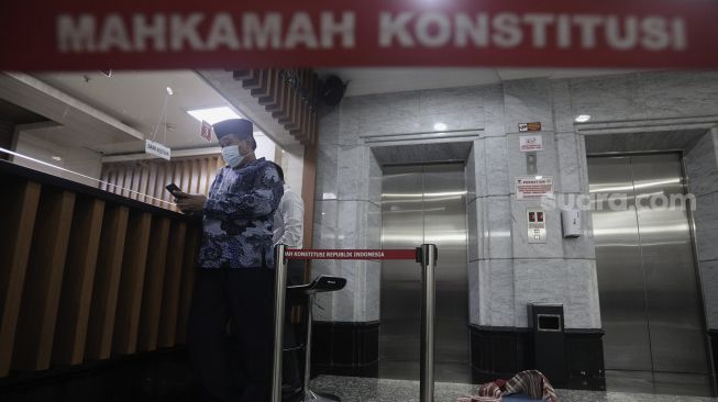 Koordinator Masyarakat Anti Korupsi Indonesia (MAKI) Boyamin Saiman memberikan berkas uji materi di Mahkamah Konstitusi, Jakarta, Senin (31/5/2021). [Suara.com/Angga Budhiyanto]