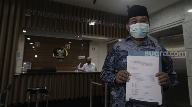 Koordinator Masyarakat Anti Korupsi Indonesia (MAKI) Boyamin Saiman menunjukkan berkas uji materi di Mahkamah Konstitusi, Jakarta, Senin (31/5/2021). [Suara.com/Angga Budhiyanto]