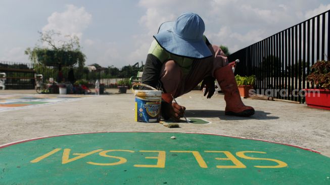 Petugas menyelesaikan pembuatan permainan tradisional di Taman Sungai Kendal, Cilincing, Jakarta Utara, Senin (31/5/2021). [Suara.com/Dian Latifah]