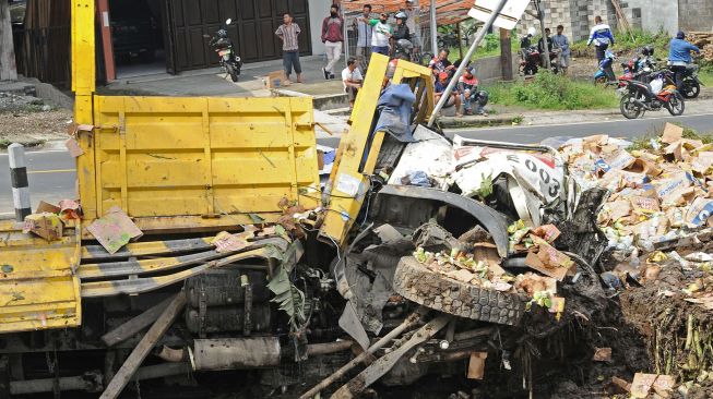 Warga menyaksikan bangkai truk tronton bernomor polisi S 9121 UH yang mengalami kecelakaan di Jalan Raya Magelang-Wonosobo Gondang, Candimulyo, Kertek, Wonosobo, Jateng, Senin (31/5/2021).  ANTARA FOTO/Anis Efizudin