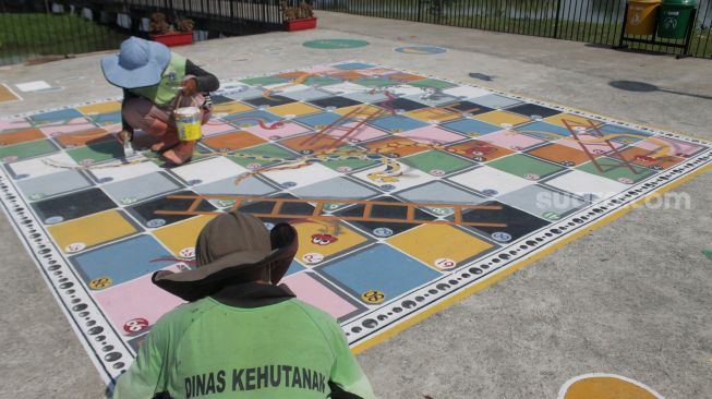 Petugas menyelesaikan pembuatan permainan tradisional di Taman Sungai Kendal, Cilincing, Jakarta Utara, Senin (31/5/2021). [Suara.com/Dian Latifah]