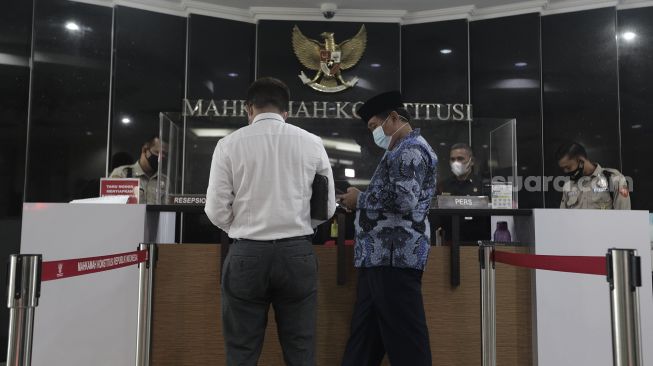 Koordinator Masyarakat Anti Korupsi Indonesia (MAKI) Boyamin Saiman (ketiga kanan) tiba untuk memberikan berkas uji materi di Mahkamah Konstitusi, Jakarta, Senin (31/5/2021). [Suara.com/Angga Budhiyanto]