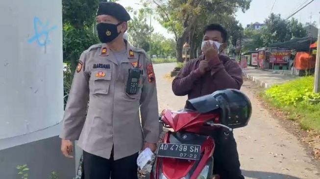 Anggota Pospam Tugu Makutho Rutin Membagikan Masker ke Pengguna Kendaraan