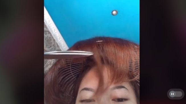 Aksi wanita potong rambut pakai kipas angin (tiktok.com/@farahkuiin)