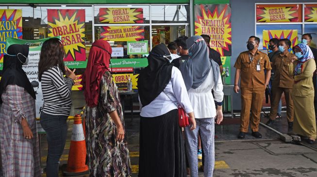 Sejumlah angota Satgas Penanggulangan COVID-19 mengawasi warga yang antre masuk gerai Giant Swalayan agar tidak terjadi kerumunan di Sempu, Serang, Banten, Senin (31/5/2021). ANTARA FOTO/Asep Fathulrahman