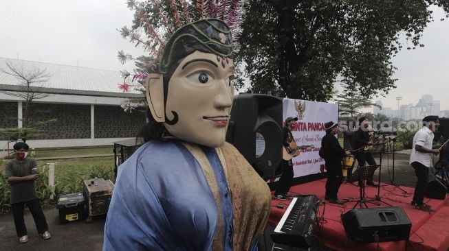 Pengamen jalanan bermain musik saat Peringatan Hari Lahir Pancasila di Kompleks Gelora Bung Karno, Jakarta, Selasa (1/6/2021). [Suara.com/Angga Budhiyanto]