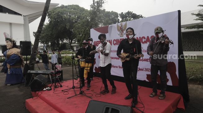 Pengamen jalanan bermain musik saat Peringatan Hari Lahir Pancasila di Kompleks Gelora Bung Karno, Jakarta, Selasa (1/6/2021). [Suara.com/Angga Budhiyanto]