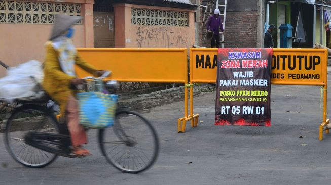 Warga melintasi jalan desa yang ditutup akibat karantina wilayah di Desa Pedawang, Kudus, Jawa Tengah, Selasa (1/6/2021). ANTARA FOTO/Yusuf Nugroho