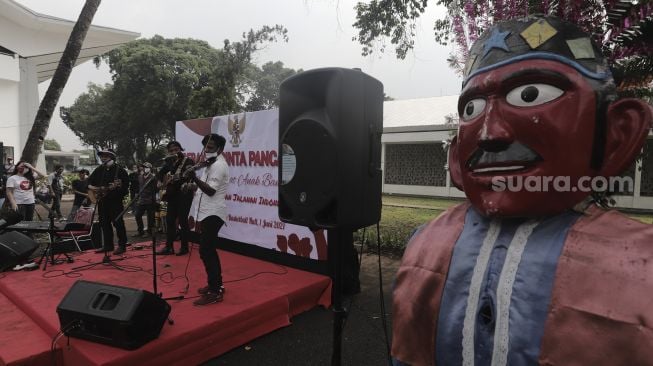 Pengamen jalanan bermain musik saat Peringatan Hari Lahir Pancasila di Kompleks Gelora Bung Karno, Jakarta, Selasa (1/6/2021). [Suara.com/Angga Budhiyanto]