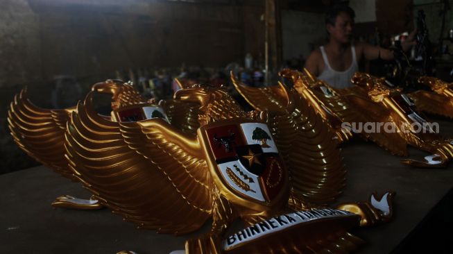 Perajin menyelesaikan pembuatan Patung Garuda di Jalan Bali Raya, Kalimalang, Jakarta Timur, Rabu (2/6/2021).  [Suara.com/Dian Latifah]