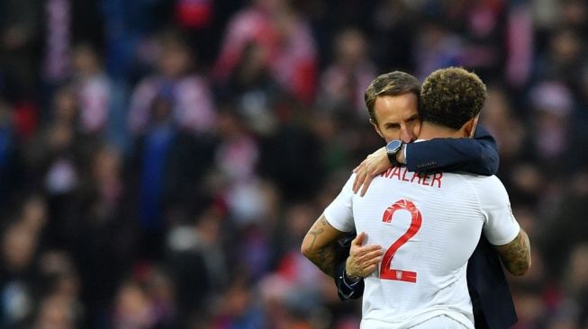 Pelatih Timnas Inggris, Gareth Southgate memeluk bek kanan Kyle Walker dalam laga UEFA Nations League kontra Kroasia di Stadion Wembley, 18 November 2018. [Ben STANSALL / AFP].