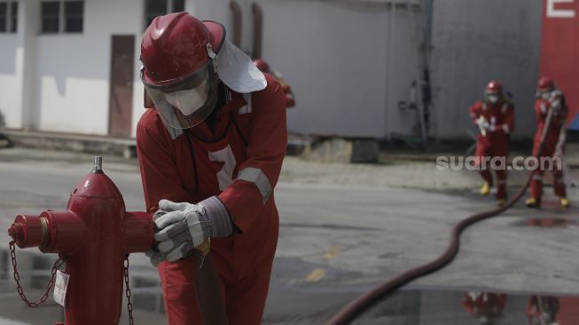 Petugas pemadam kebakaran melakukan simulasi penyelamatan saat kompetisi Fire Safety Challenge (FSC) antar Suku Dinas Pemadam Kebakaran di Kantor Dinas Penanggulangan Kebakaran dan Penyelamatan Pemprov DKI Jakarta, Gambir, Jakarta, Rabu (2/6/2021). [Suara.com/Angga Budhiyanto]