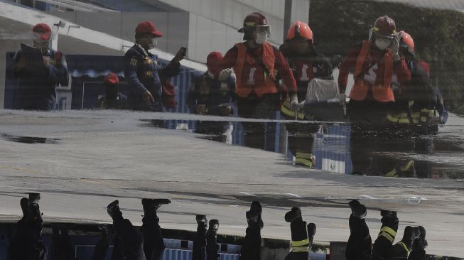 Refleksi peserta mengikuti simulasi penyelamatan saat kompetisi Fire Safety Challenge (FSC) antar Suku Dinas Pemadam Kebakaran di Kantor Dinas Penanggulangan Kebakaran dan Penyelamatan Pemprov DKI Jakarta, Gambir, Jakarta, Rabu (2/6/2021). [Suara.com/Angga Budhiyanto]