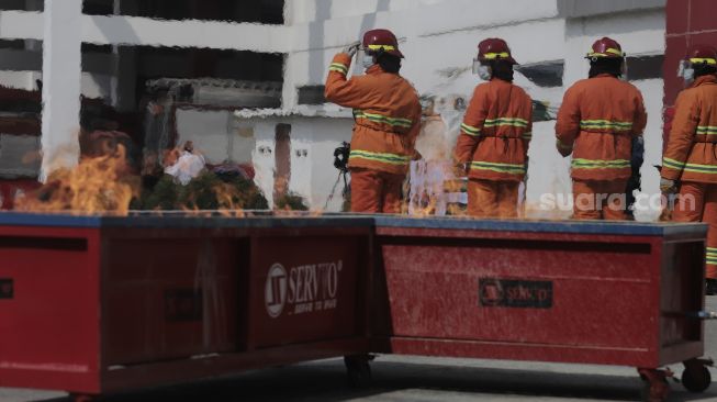 Petugas pemadam kebakaran melakukan simulasi penyelamatan saat kompetisi Fire Safety Challenge (FSC) antar Suku Dinas Pemadam Kebakaran di Kantor Dinas Penanggulangan Kebakaran dan Penyelamatan Pemprov DKI Jakarta, Gambir, Jakarta, Rabu (2/6/2021). [Suara.com/Angga Budhiyanto]