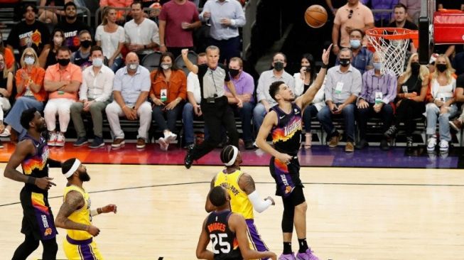 Pemain Phoenix Suns Devin Booker memasukkan lemparan dan sekaligus memaksa lawannya Los Angeles Lakers melakukan pelanggaran pada paruh pertama babak pertama playoff Wilayah Barat di Phoenix Suns Arena, Phoenix, Arizona, 1 Juni 2021. (Getty Images via AFP/CHRISTIAN PETERSEN)