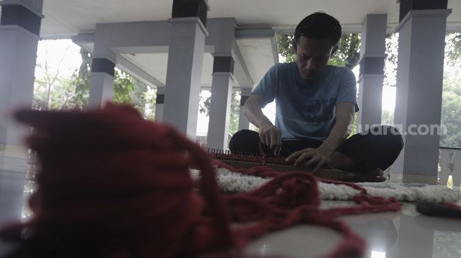 Orang dengan masalah kejiwaan (ODMK) berlatih membuat keset kain perca di Panti Sosial Bina Insan Bangun Daya 2, Cipayung, Jakarta, Kamis (3/6/2021). [Suara.com/Angga Budhiyanto]