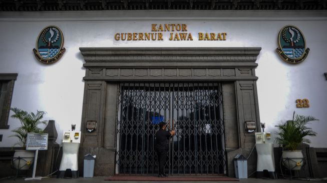 Petugas keamanan mengunci pintu utama Gedung Sate, Bandung, Jawa Barat, Kamis (3/6/2021). ANTARA FOTO/Raisan Al Farisi