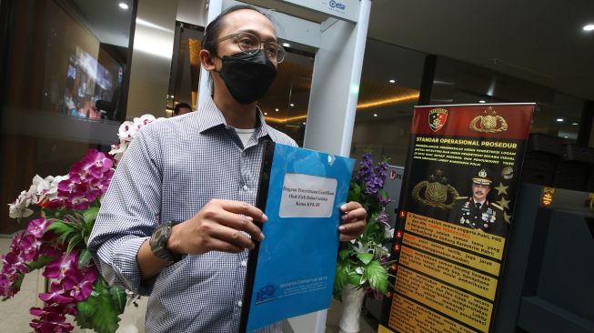 Peneliti Indonesia Corruption Watch (ICW) Wana Alamsyah menunjukan dokumen laporan saat tiba di Bareskrim Polri, Jakarta, Kamis (3/6/2021). ANTARA FOTO/Rivan Awal Lingga