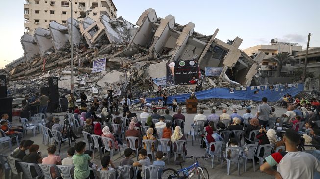 Musisi Palestina tampil di antara puing-puing reruntuhan Menara Hanadi di Kota Gaza, pada (2/6/2021). [MOHAMMED ABED / AFP]