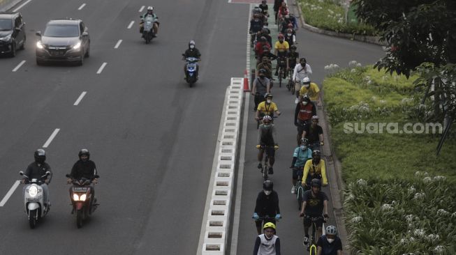 Pesepeda melintasi jalur khusus sepeda di Jalan Jenderal Sudirman, Jakarta, Sabtu (5/6/2021). [Suara.com/Angga Budhiyanto]