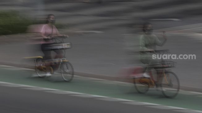 Pesepeda melintasi jalur khusus sepeda di Jalan Jenderal Sudirman, Jakarta, Sabtu (5/6/2021). [Suara.com/Angga Budhiyanto]