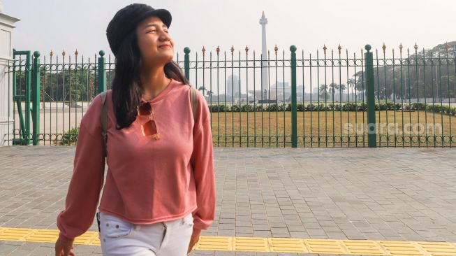 Juara Bintang Suara Aurelya Ratamchia Dewanda saat  berwisata mengunjungi Monumen Nasional (Monas) di Jakarta Pusat, Minggu (6/5/2021). [Suara.com/Alfian Winanto]