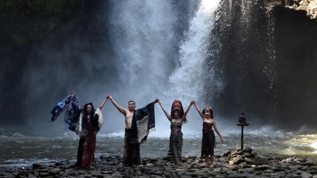 Sejumlah model menampilkan rancangan kain tradisional atau wastra nusantara yang diperagakan di area air terjun Tegenungan, Gianyar, Bali, Sabtu (5/6/2021). ANTARA FOTO/Nyoman Hendra Wibowo
