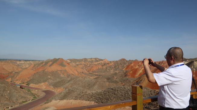 Seorang wisatawan memotret panorama bukit warna-warni Taman Bumi Danxia di Kota Zhangye, Provinsi Gansu, China, Sabtu (5/6/2021).  ANTARA FOTO/M. Irfan Ilmie
