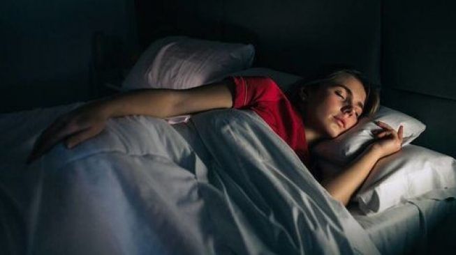 Ilustrasi tidur dengan lampu mati. (Stocksy)