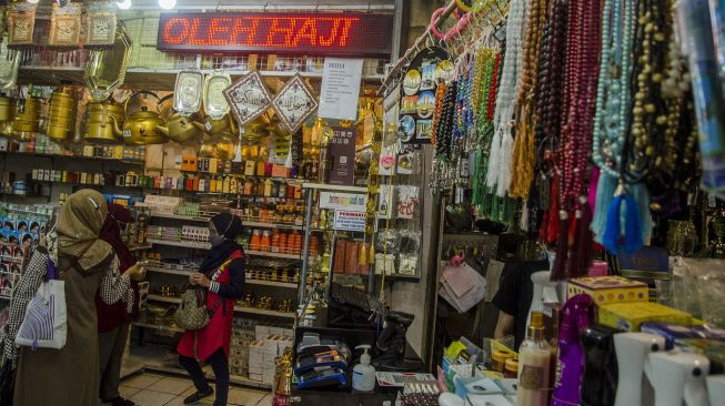 Penjual oleh-oleh haji dan umrah melayani konsumen di Pasar Baru Trade Center, Bandung, Jawa Barat, Selasa (8/6/2021).  ANTARA FOTO/Novrian Arbi
