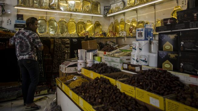 Penjual oleh-oleh haji dan umrah merapikan dagangannya di Pasar Baru Trade Center, Bandung, Jawa Barat, Selasa (8/6/2021).  ANTARA FOTO/Novrian Arbi
