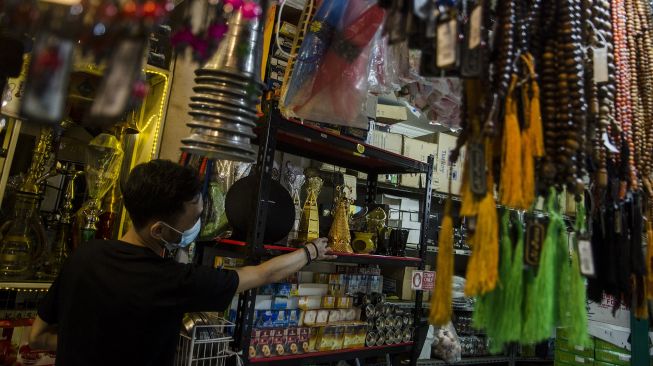 Penjual oleh-oleh haji dan umrah merapikan dagangannya di Pasar Baru Trade Center, Bandung, Jawa Barat, Selasa (8/6/2021).  ANTARA FOTO/Novrian Arbi
