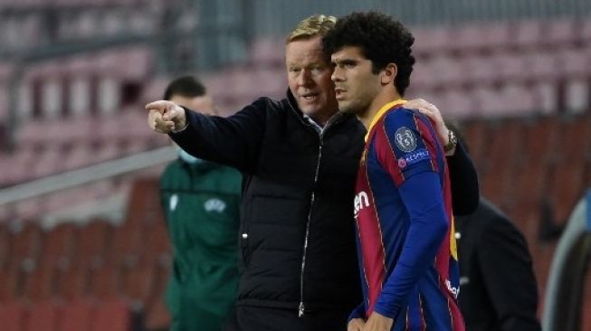 Gelandang muda Barcelona Carles Alena mendengarkan instruksi pelatih Ronald Koeman saat menghadapi Dynamo Kiev di fase grup Liga Champions yang digelar di Camp Nou pada 4 November 2020. [AFP]